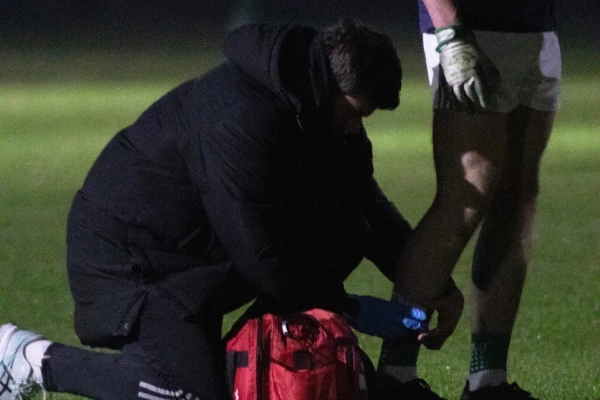 Urosh putting tape around an athlete's shin